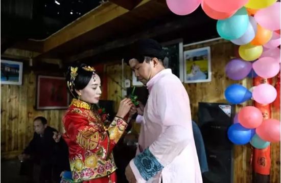 婚礼开始前，吴春霞为施六金佩戴胸花(2018年9月24日摄)。