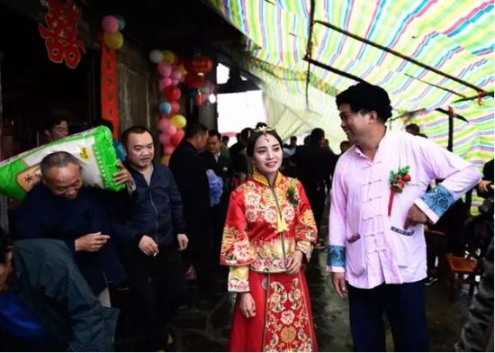 婚礼开始前，施六金和新娘吴春霞在门口迎接客人(2018年9月24日摄)。