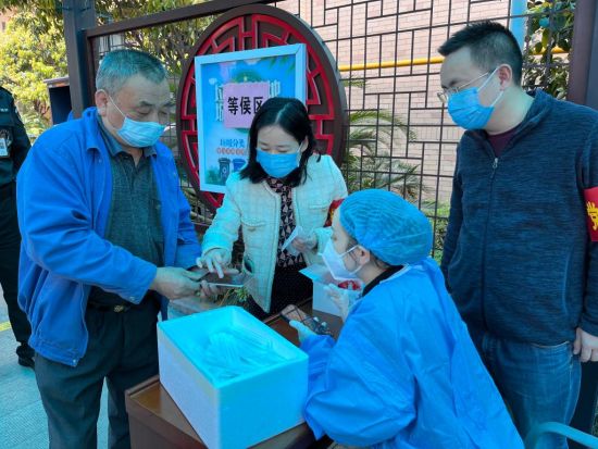 湖南省税务局青年党员主动参与雨花区全员核酸检测志愿者工作，引导社区居民扫码检测。罗舜爱 摄
