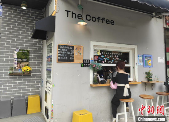 图为4月10日，顾客在吴家成开的咖啡店里消费。 中新社记者 邓霞 摄