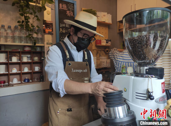 图为4月10日，吴家成正在制作咖啡。 中新社记者 邓霞 摄