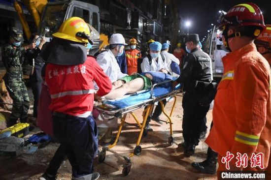 4月29日23时许，救援人员将一名获救的被困者送上救护车。　杨华峰 摄