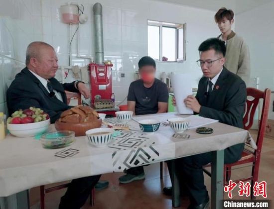 庞文秀(左一)和同事耐心为农户普及法律知识。　湖南卫视供图
