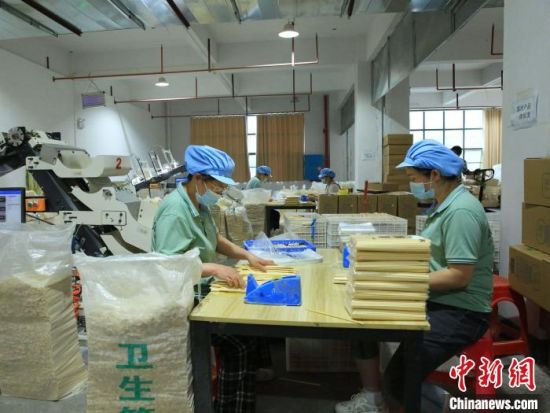 湖南辰铭竹木制品有限公司的生产车间，工人们将竹筷进行分拣打包装袋。　易子明 摄